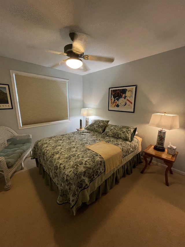 bedroom featuring carpet floors, a textured ceiling, and a ceiling fan