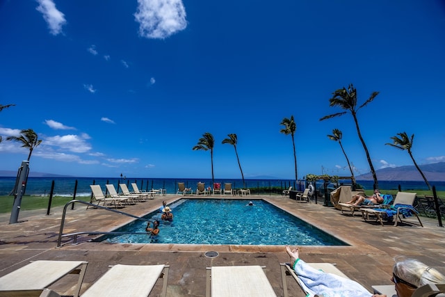 view of swimming pool featuring a water view and a patio area