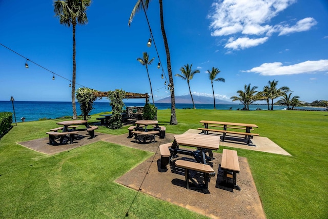 view of community featuring a patio, a water and mountain view, and a lawn