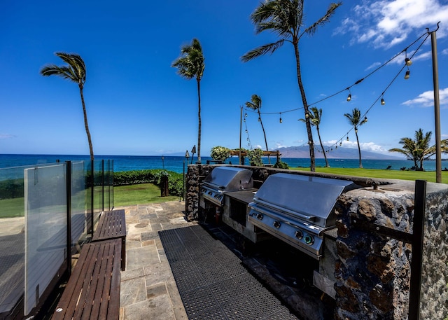 view of patio featuring area for grilling, a grill, and a water and mountain view