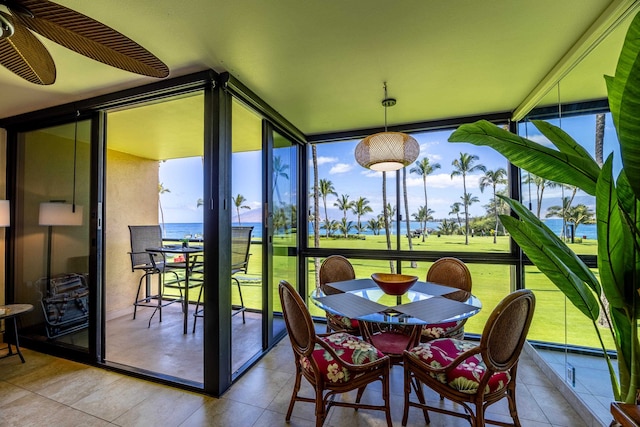 sunroom / solarium with ceiling fan, a water view, and a healthy amount of sunlight