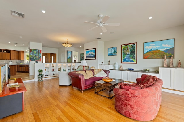 living room with ceiling fan and light wood-type flooring