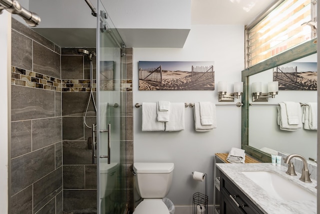 bathroom featuring an enclosed shower, toilet, and vanity