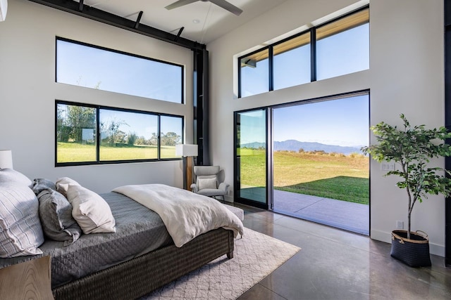 bedroom featuring a high ceiling, a mountain view, and access to exterior