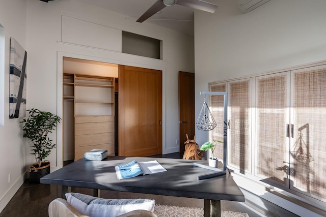 office space with a high ceiling and ceiling fan