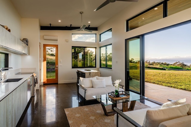 interior space featuring sink, a towering ceiling, a wall mounted AC, and ceiling fan
