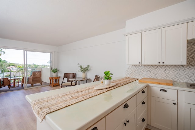 kitchen featuring backsplash, white cabinets, and light hardwood / wood-style floors