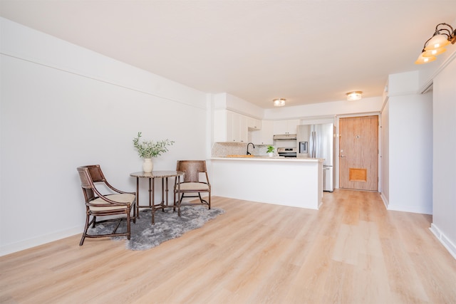 living area with sink and light hardwood / wood-style floors