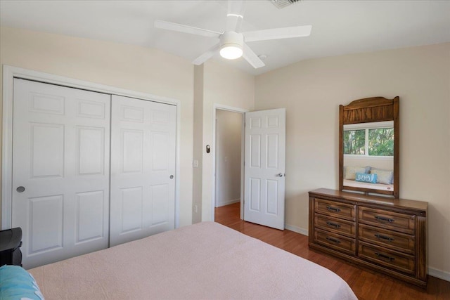 bedroom featuring vaulted ceiling, dark hardwood / wood-style floors, ceiling fan, and a closet