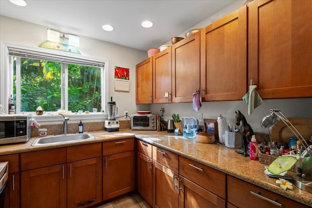 kitchen featuring light stone countertops, sink, and light tile patterned floors