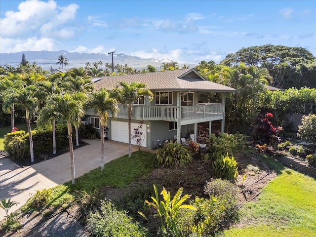 view of front of property featuring a balcony, a garage, and a mountain view