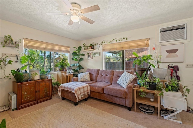 living room featuring ceiling fan, a wall unit AC, a wealth of natural light, and a textured ceiling