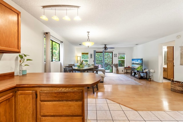 kitchen featuring plenty of natural light, a peninsula, open floor plan, and light tile patterned flooring