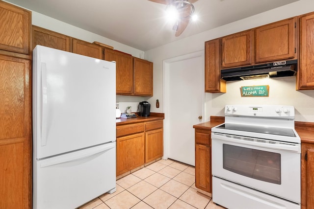 kitchen featuring light tile patterned floors, white appliances, brown cabinets, and under cabinet range hood