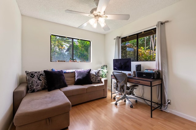 office featuring a textured ceiling, baseboards, and wood finished floors