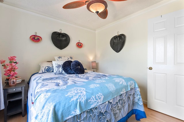 bedroom with a ceiling fan, crown molding, a textured ceiling, and wood finished floors