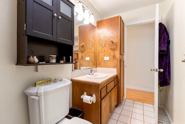 half bath with vanity, tile patterned flooring, and toilet