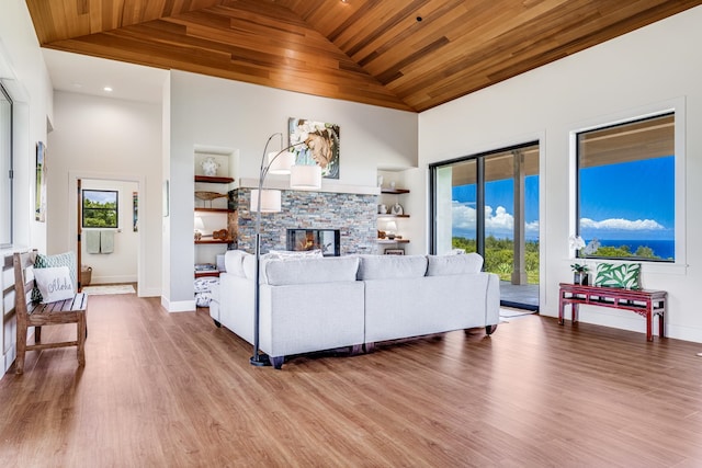 living room featuring wood ceiling, a fireplace, and plenty of natural light