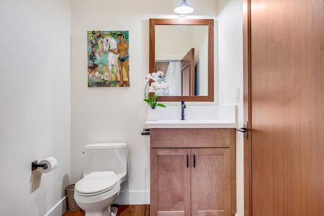 bathroom with vanity, hardwood / wood-style floors, and toilet