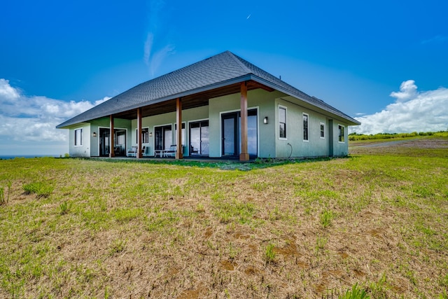 rear view of property featuring a yard