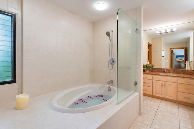 bathroom featuring tiled shower / bath combo, tile floors, a healthy amount of sunlight, and vanity