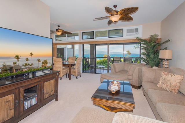 carpeted living room with ceiling fan, a healthy amount of sunlight, and a water view