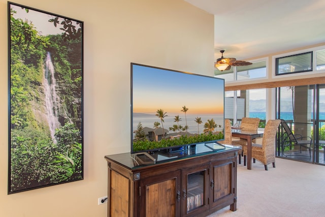 interior space featuring a water view, ceiling fan, and light colored carpet