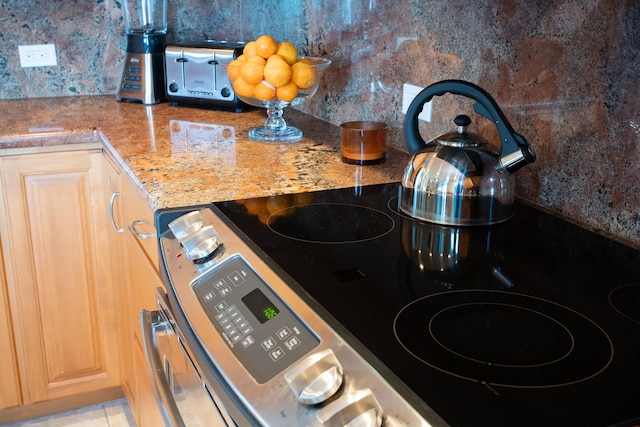 details featuring stainless steel electric range oven and light tile flooring