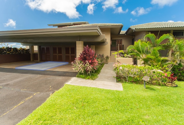 view of front of house featuring a carport and a front yard