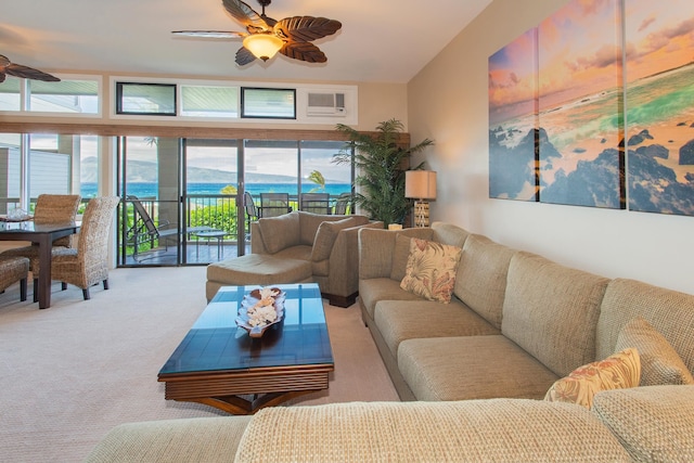 living room featuring ceiling fan, a water view, light colored carpet, and plenty of natural light