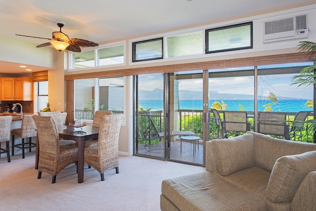 interior space featuring a water and mountain view, sink, a wall unit AC, and ceiling fan