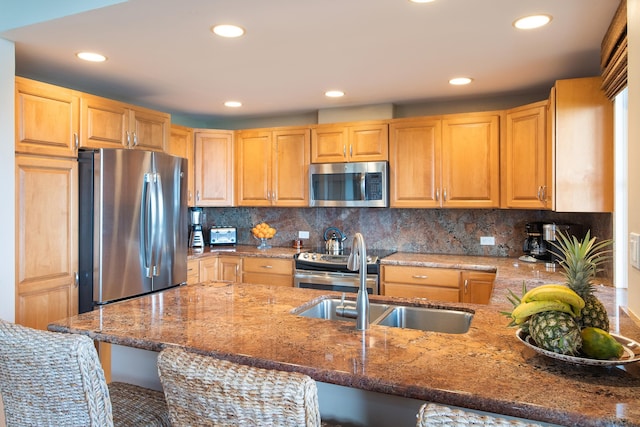 kitchen with tasteful backsplash, a breakfast bar, stainless steel appliances, sink, and light stone countertops