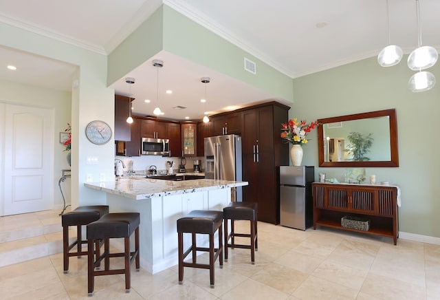 kitchen featuring kitchen peninsula, light stone countertops, pendant lighting, and stainless steel appliances