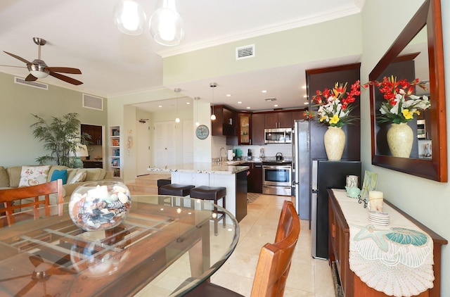 dining space featuring light tile patterned floors, ceiling fan, ornamental molding, and sink