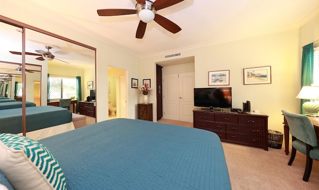 carpeted bedroom featuring ceiling fan, ornamental molding, and a closet