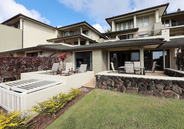 back of property featuring a balcony and a patio