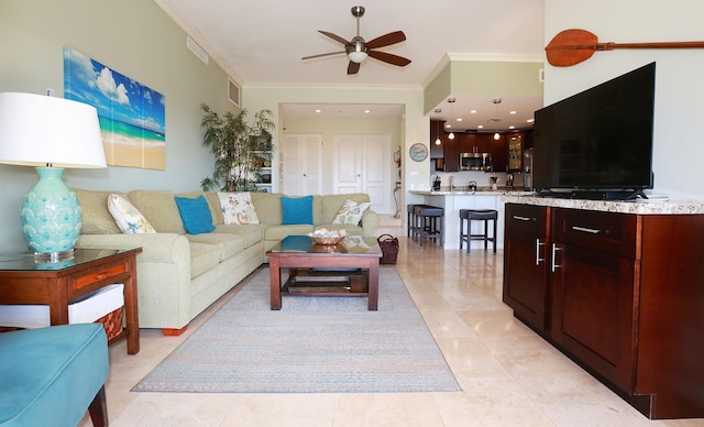 tiled living room with ceiling fan and crown molding