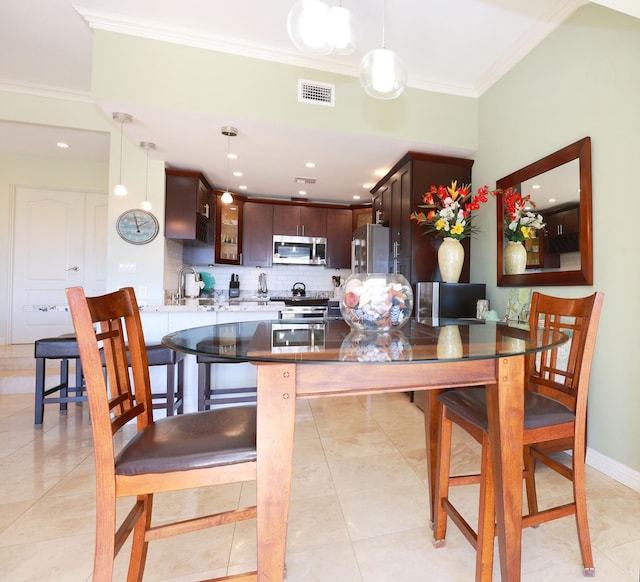 dining area with sink, light tile patterned floors, and ornamental molding