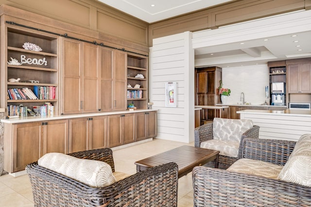 sitting room featuring wood walls, sink, and light tile patterned floors