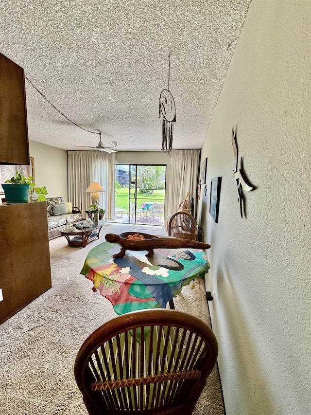 interior space featuring ceiling fan, a textured ceiling, and carpet