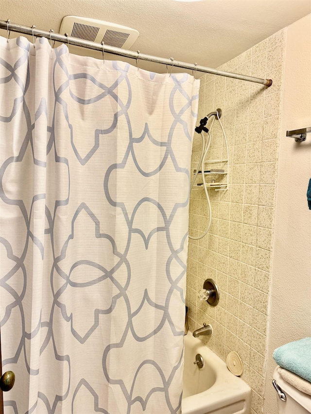 bathroom with toilet and shower / bath combo