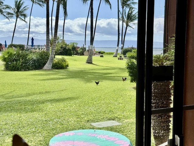 view of property's community with a lawn and a water view