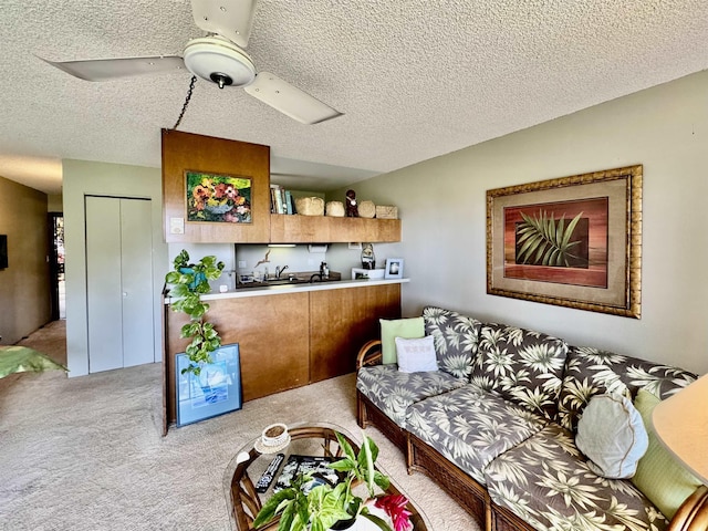 living room with ceiling fan, light colored carpet, and a textured ceiling