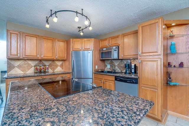 30 Hauoli St Unit 212, Wailuku, HI 96793 - kitchen featuring stainless steel appliances, a sink, backsplash, a textured ceiling, and dark stone countertops