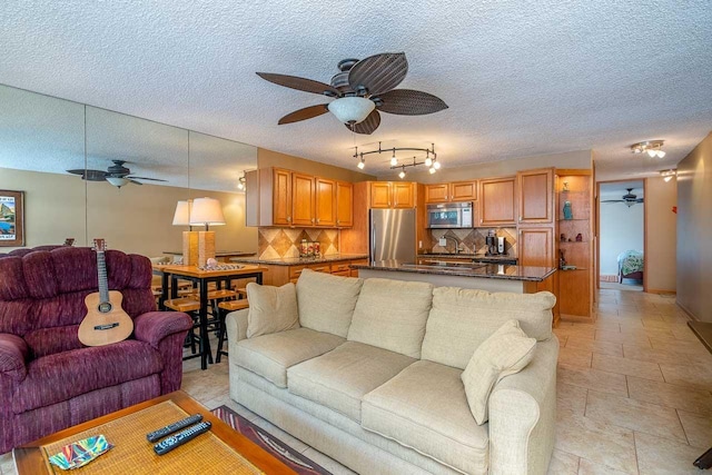 30 Hauoli St Unit 212, Wailuku, HI 96793 - living room featuring a ceiling fan and a textured ceiling