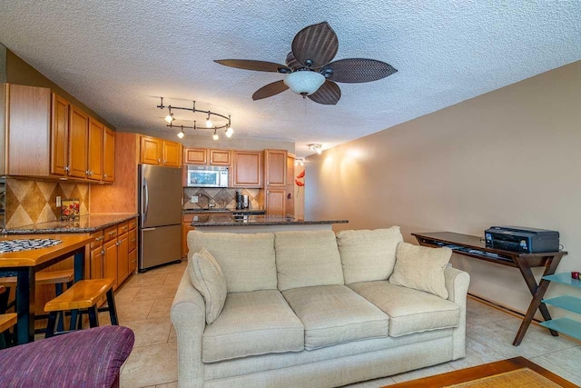 30 Hauoli St Unit 212, Wailuku, HI 96793 - living area featuring a textured ceiling, ceiling fan, track lighting, and light tile patterned floors
