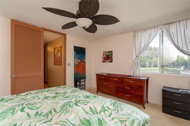 30 Hauoli St Unit 212, Wailuku, HI 96793 - bedroom with light carpet, a closet, a textured ceiling, a ceiling fan, and a walk in closet