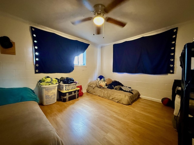 bedroom featuring wood-type flooring, crown molding, and ceiling fan