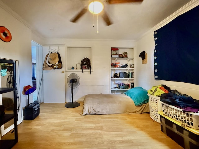 interior space featuring ceiling fan, ornamental molding, and light wood-type flooring