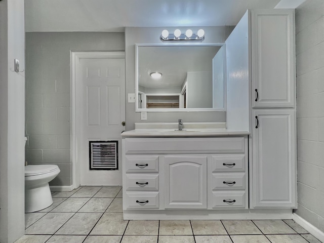 bathroom featuring vanity, tile patterned flooring, and toilet